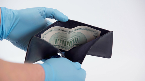 cropped view of person in latex gloves showing dollar banknote in wallet on white