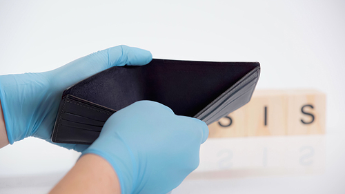 cropped view of person in latex gloves holding empty wallet on white