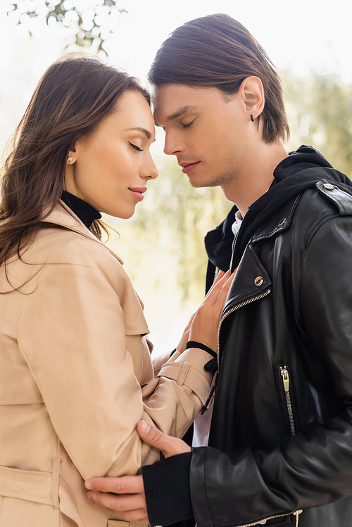 side view of sensual young woman touching chest of man with closed eyes