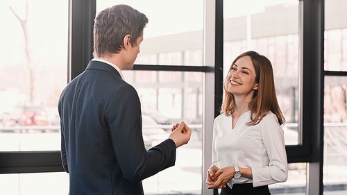 employer gesturing while talking to happy woman on job interview