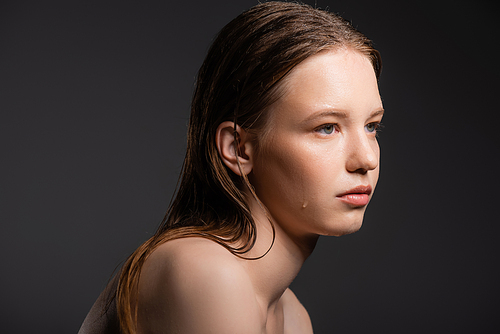 Fair haired model with wet face looking away isolated on grey