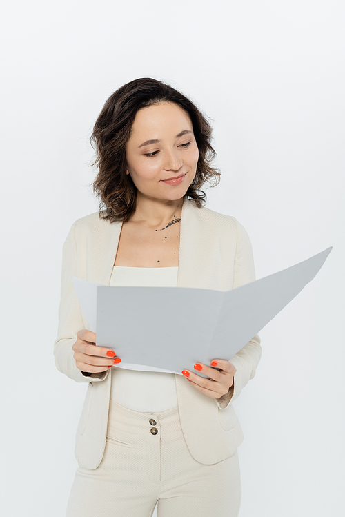 Brunette businesswoman holding paper folder isolated on grey