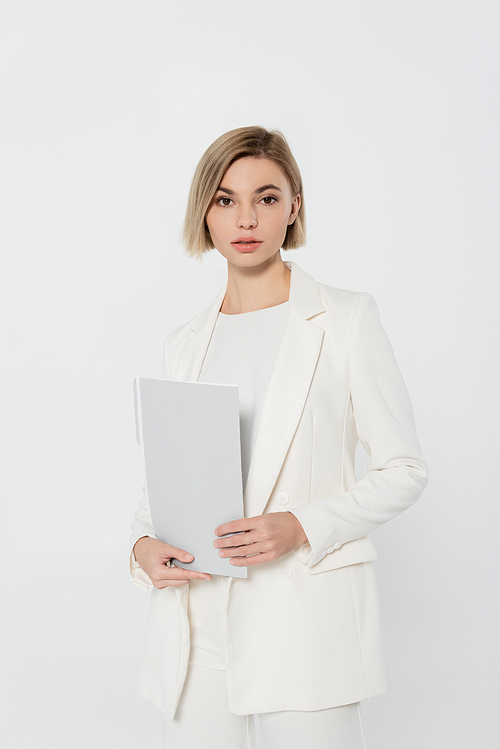 Blonde businesswoman in suit holding paper folder isolated on grey