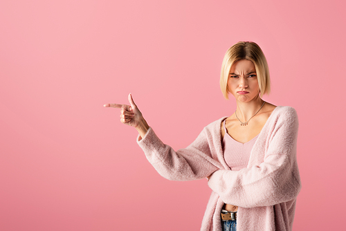 displeased woman pointing with finger isolated on pink