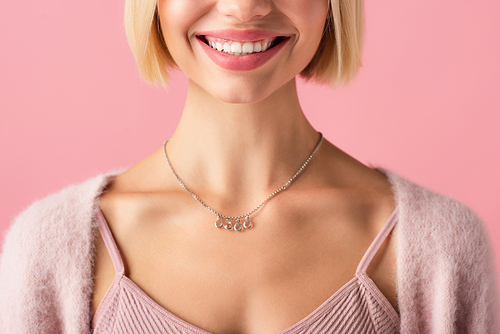 cropped view of happy young woman smiling isolated on pink