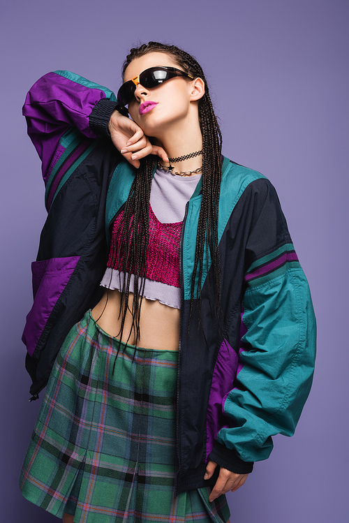 Trendy woman in vintage plaid skirt and sports jacket isolated on purple