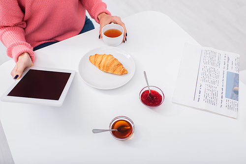 cropped view of woman holding digital tablet with blank screen during breakfast