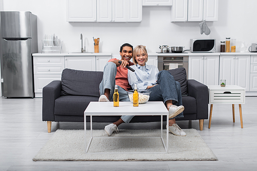 happy interracial couple watching movie together