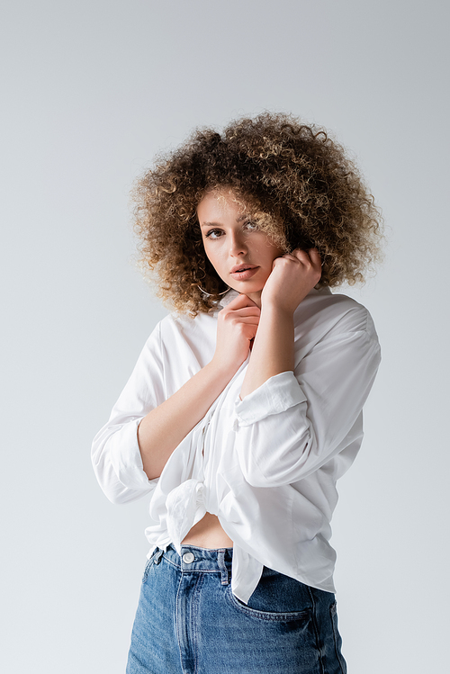 Pretty curly woman in blouse posing isolated on white