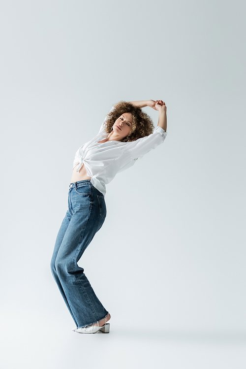 Stylish woman closing yes and posing on white background