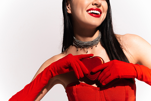 Cropped view of cheerful woman in red gloves holding heart shaped gift isolated on white