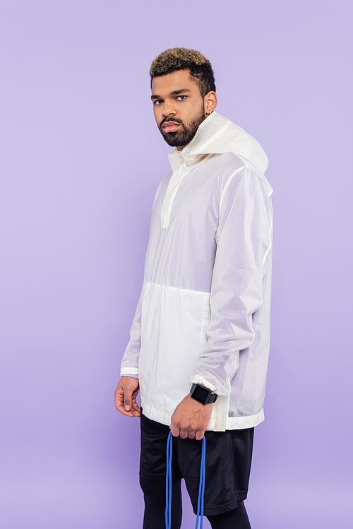 young african american man in trendy sportswear isolated on purple