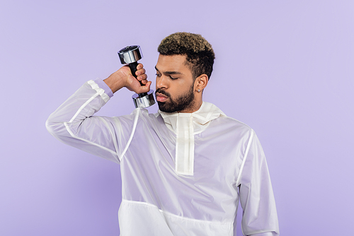 bearded african american man exercising with dumbbell isolated on purple