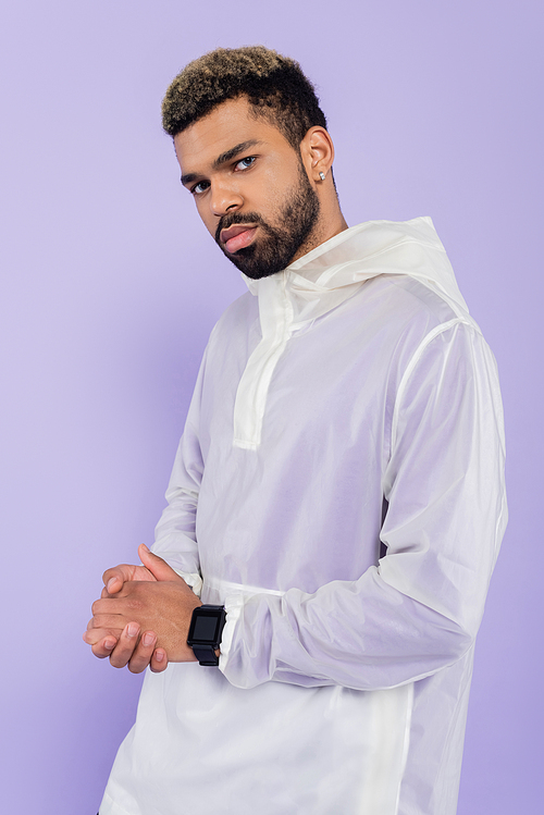 young african american sportsman with smart watch posing with clenched hands isolated on purple