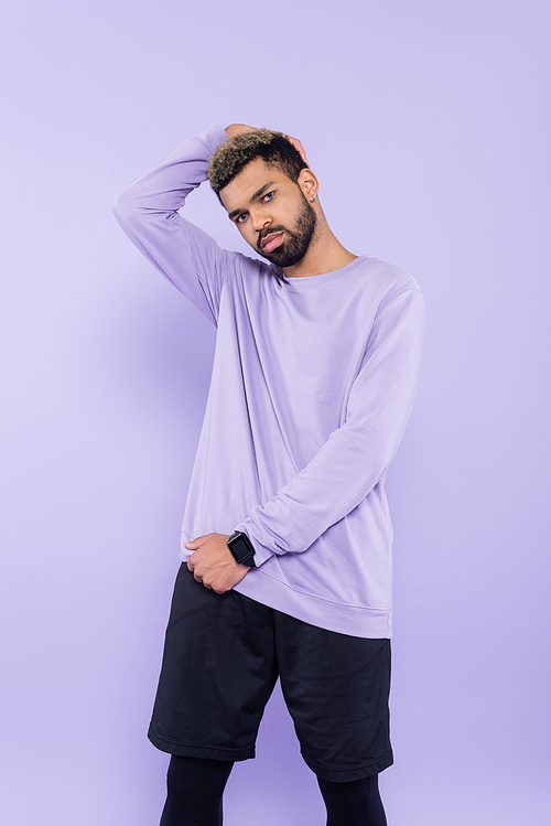 bearded african american man in sweater posing isolated on purple