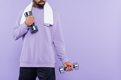 cropped view of bearded african american man with towel exercising while holding dumbbells isolated on purple