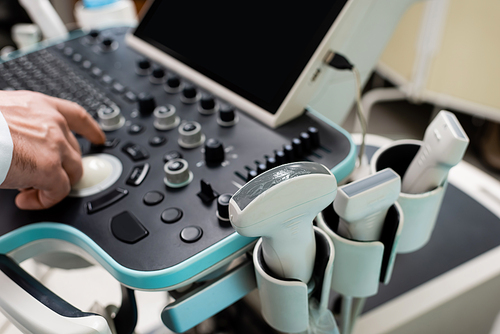 partial view of doctor using control panel of ultrasound machine in hospital