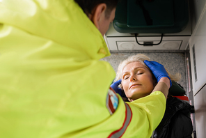 High angle view of blurred paramedic checking mature patient in emergency vehicle