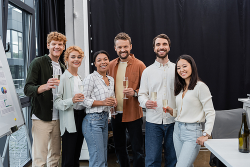 Multicultural business people holding glasses of champagne in office