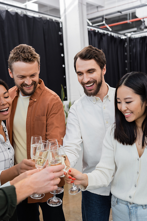 Cheerful interracial business people clinking champagne during corporate party