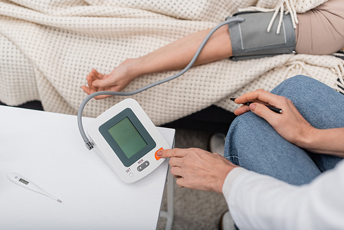 Cropped view of doctor using tonometer near patient at home