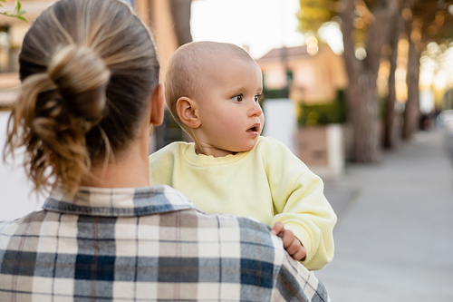 Blurred man holding toddler kid on urban street