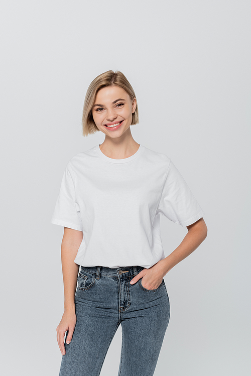 Cheerful blonde woman in t-shirt posing isolated on grey