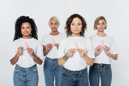 Woman holding pink ribbon of breast cancer awareness near interracial friends isolated on grey