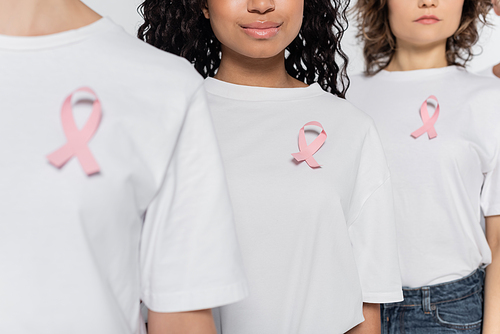 Cropped view of african american woman with pink ribbon on t-shirt standing near friends isolated on grey