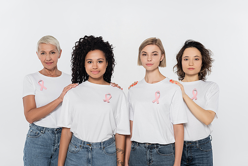 Women with pink ribbons on t-shirts touching interracial friends isolated on grey
