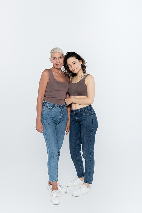 Smiling women looking at camera on grey background, feminism concept