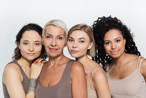 Interracial women posing together isolated on grey