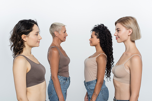 Side view of multiethnic women looking at each other isolated on grey