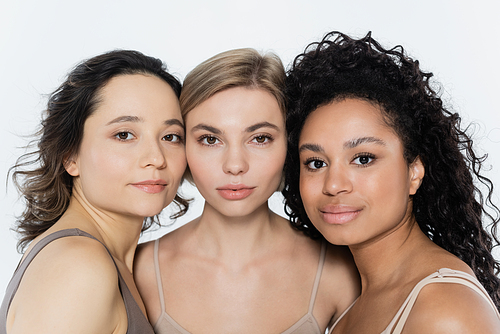 Young multiethnic women looking at camera isolated on grey, feminism concept
