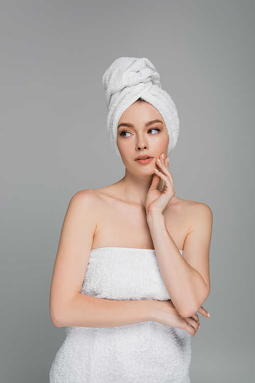 pensive young woman with towel on head looking away isolated on grey