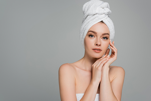 pretty young woman with bare shoulders and towel on head isolated on grey