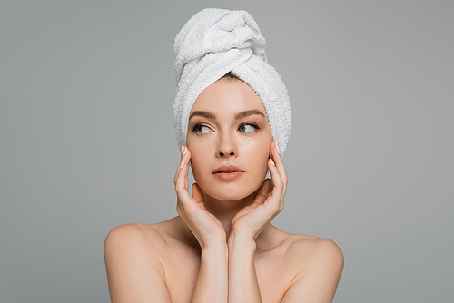 young woman with bare shoulders and towel on head looking away isolated on grey