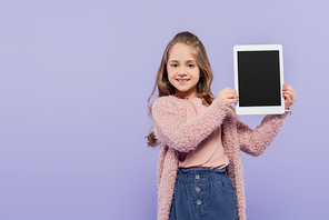 joyful girl holding digital tablet with blank screen isolated on purple