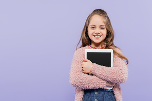 joyful girl hugging digital tablet with blank screen isolated on purple