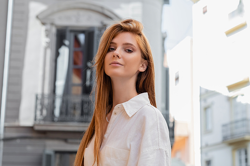 young woman with red hair looking at camera on european street in Valencia