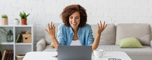 happy african american freelancer gesturing during video call on laptop, banner