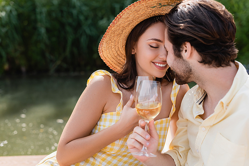 happy romantic couple holding glasses of wine outdoors
