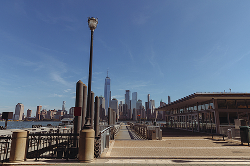 port and embankment with walkway and cityscape of modern skyscrapers in New York city