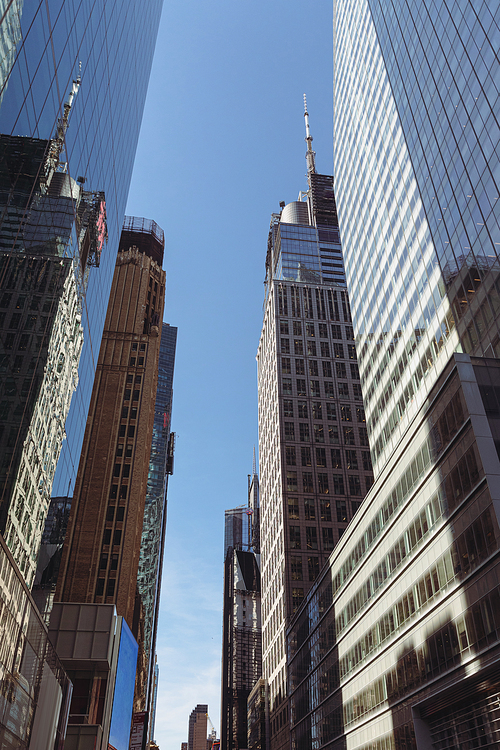 low angle view of modern skyscrapers against blue sky in financial district of New York City