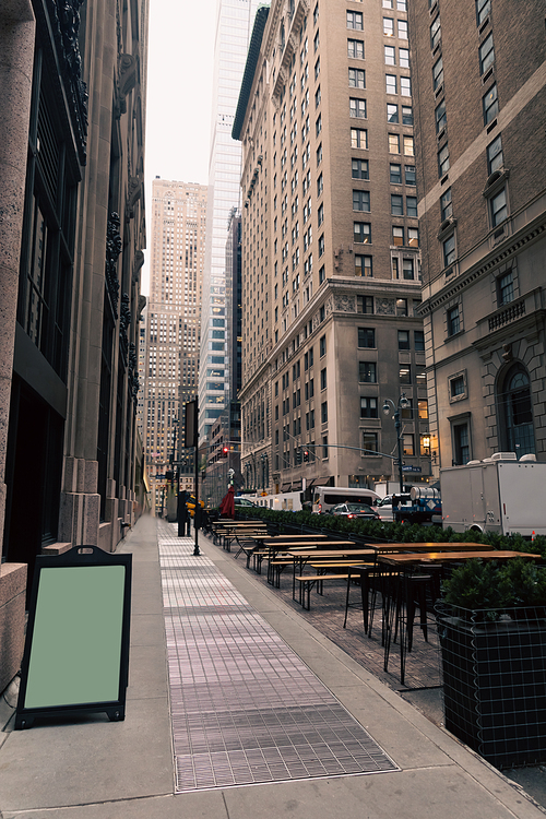 cafe terrace with empty tables and blank menu board on New York City street