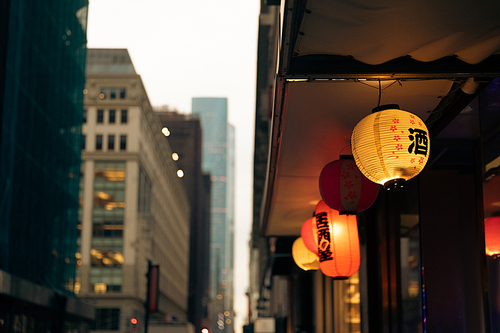 luminous lanterns with hieroglyphs in Chinese district on blurred background in New York City