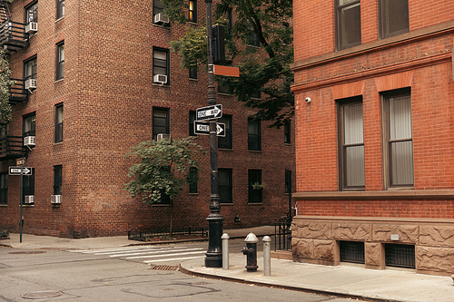 Pointers between brick buildings on street in New York City