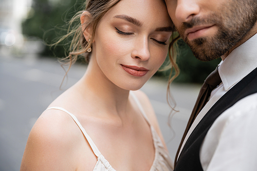 portrait of sensual bride and bearded groom in vest with tie