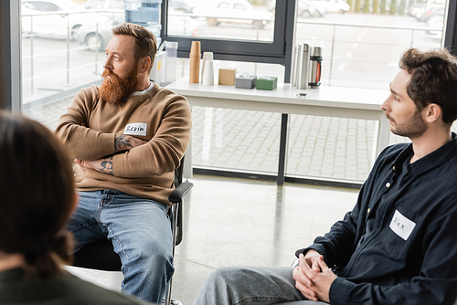 People with alcohol addiction meeting sitting on chairs during therapy in rehab center