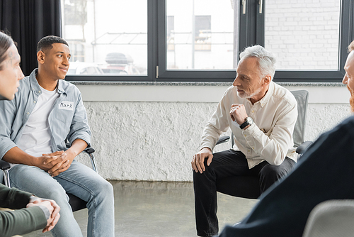 Middle aged man with alcohol addiction sharing problem during group therapy session in rehab center